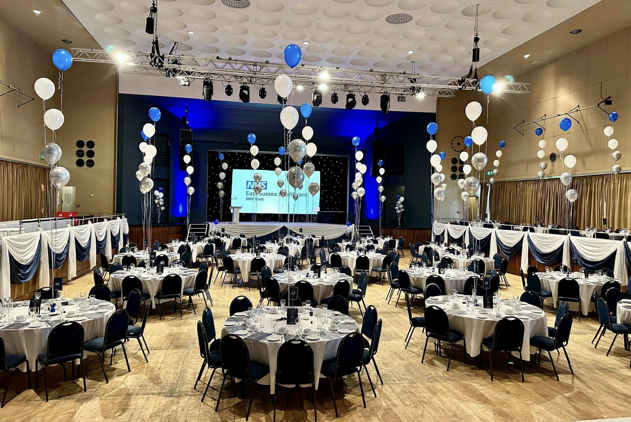 Large venue decorated with blue and white balloons